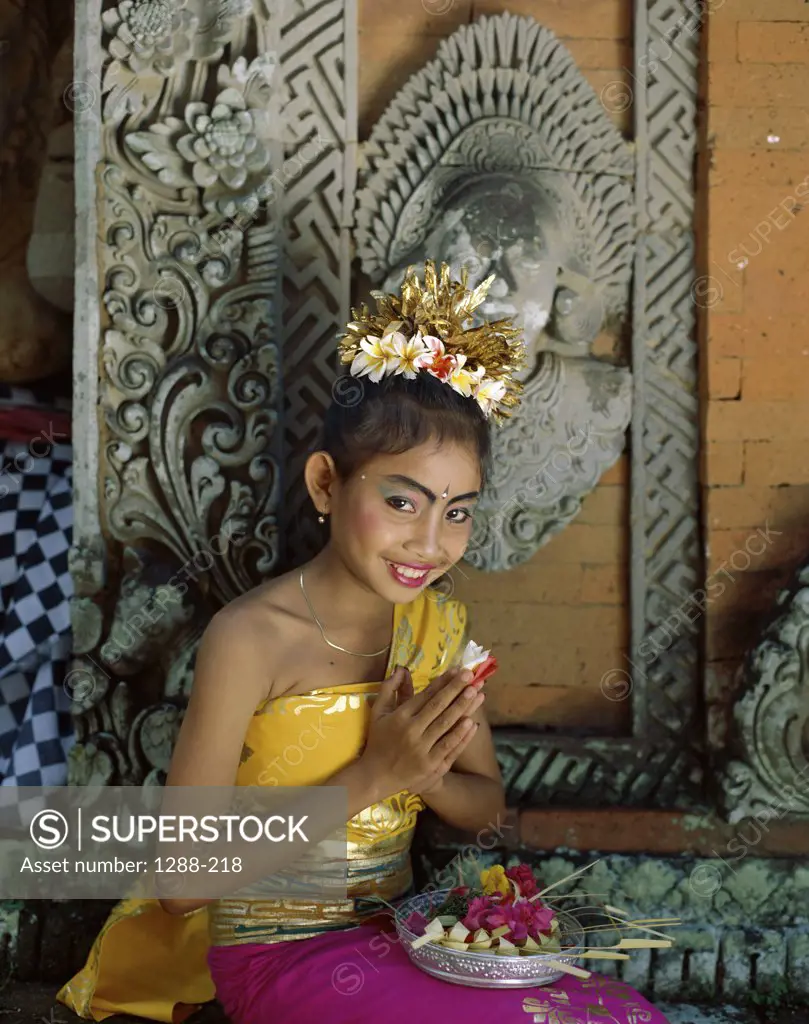Portrait of a teenage girl praying in a temple, Bali, Indonesia