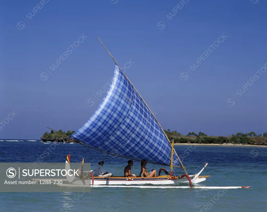 Three people sailing on a sailboat, Sanur Beach, Bali, Indonesia