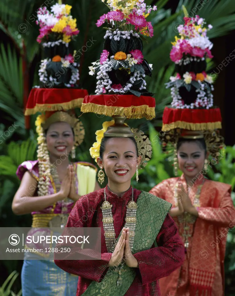 Portrait of young women standing in a prayer position, Malaysia