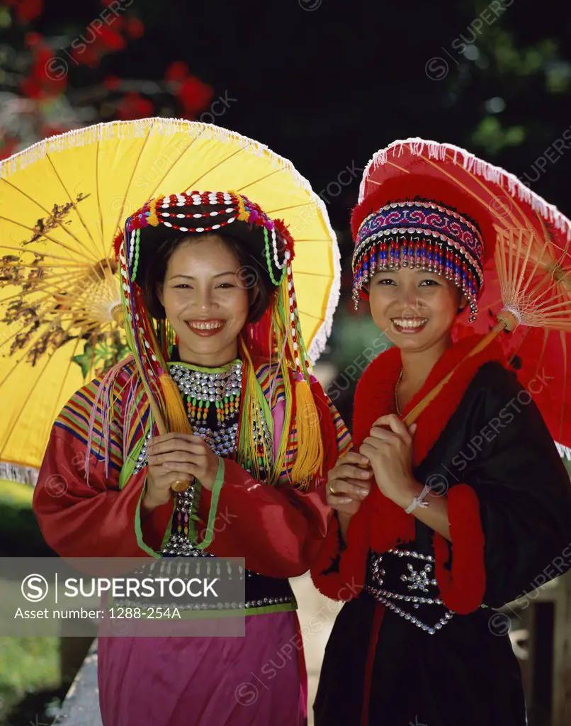 Portrait of two young women holding parasols, Chiang Mai, Thailand