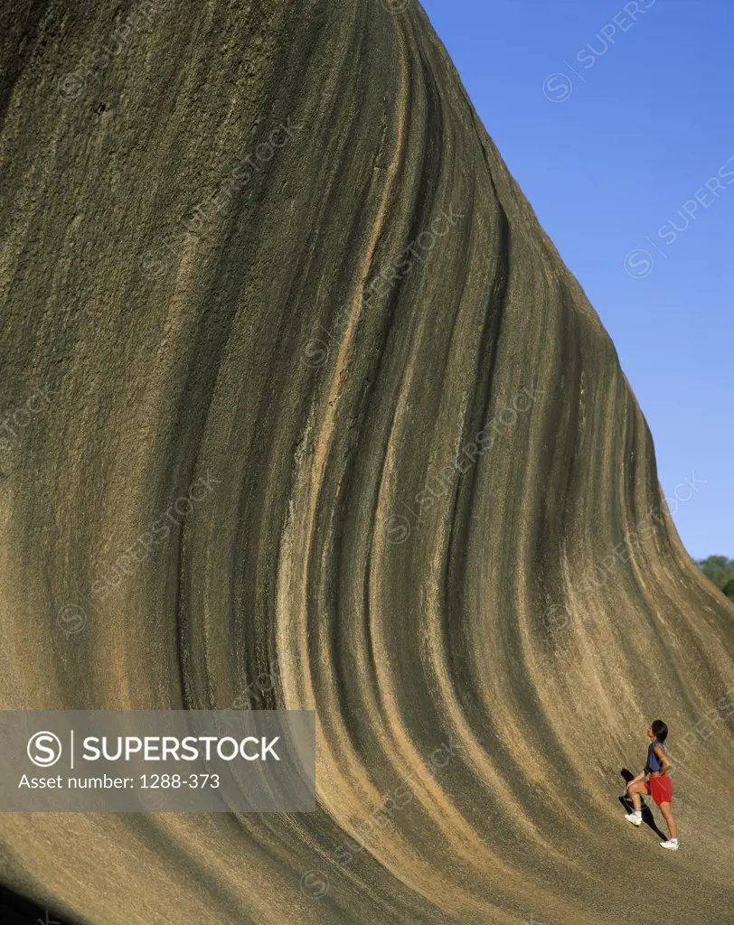 Person climbing Wave Rock, Western Australia, Australia