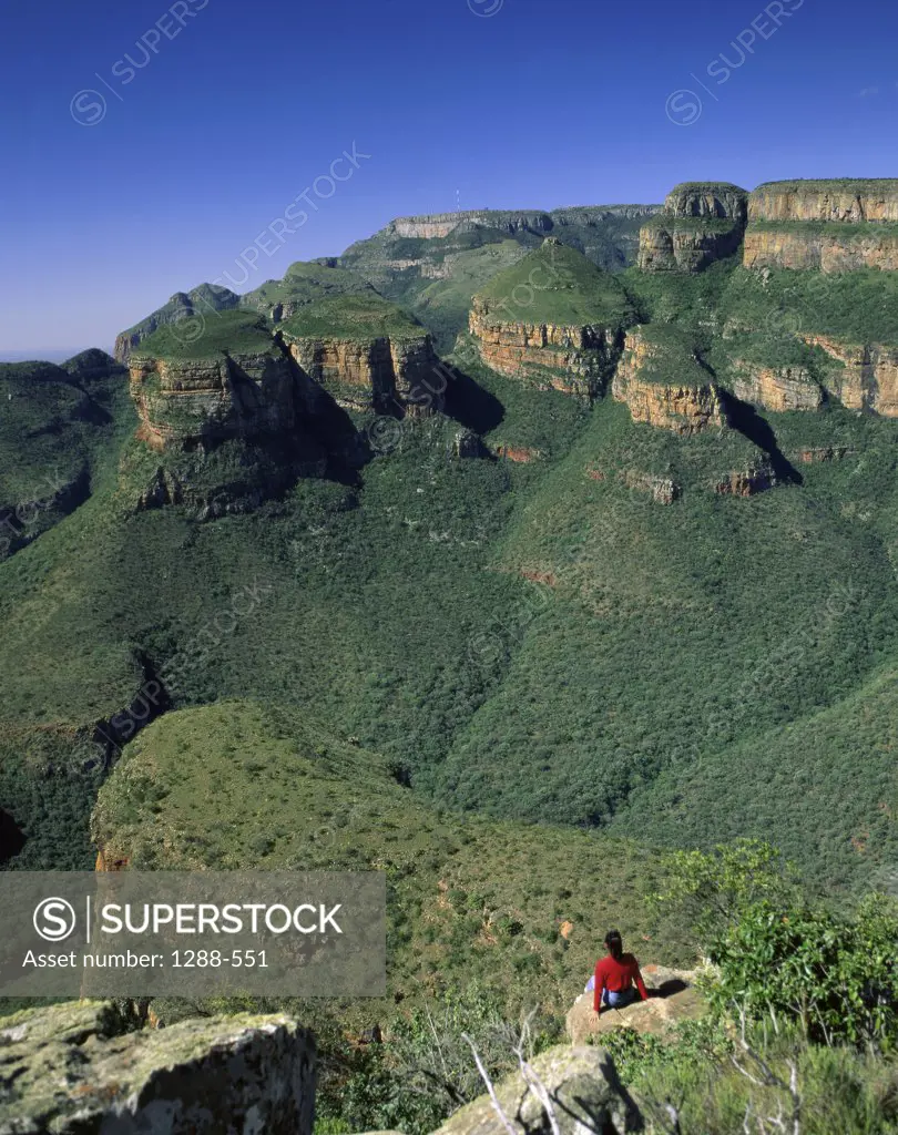 High angle view of a woman sitting on the rock, Drakensberg, Transvaal, South Africa