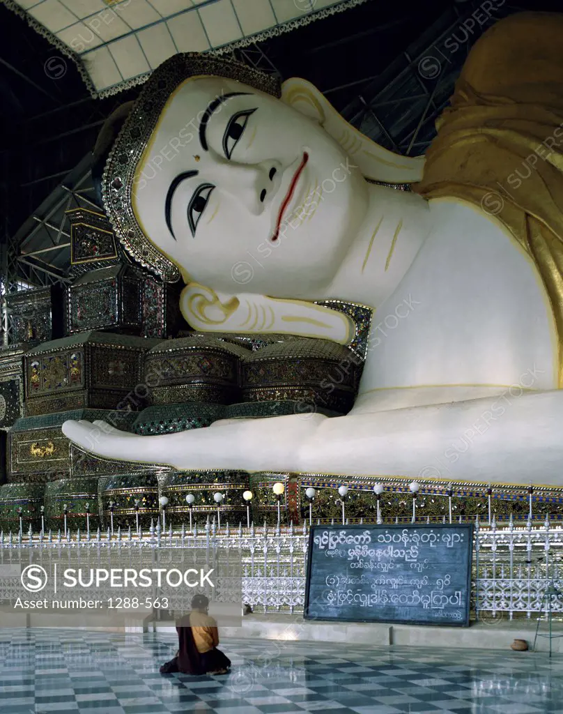 Monk sitting in front of a Buddha statue, Shwethalyaung Buddha, Bago, Myanmar