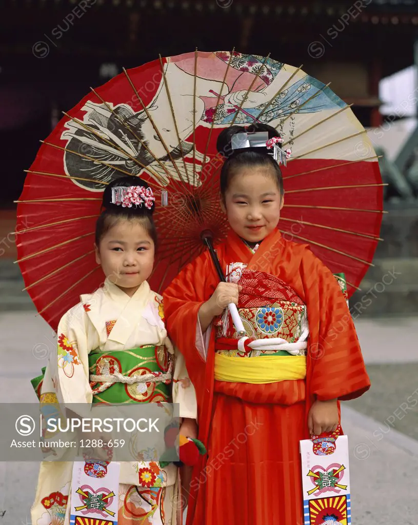 Portrait of two girls holding a parasol, Japan