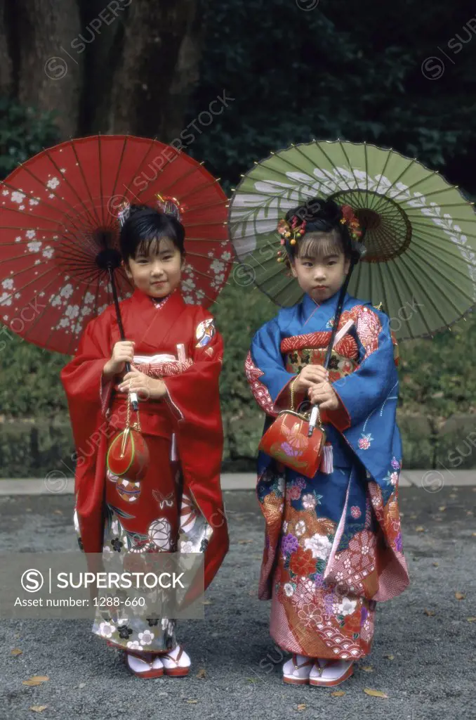 Portrait of two girls holding parasols, Japan