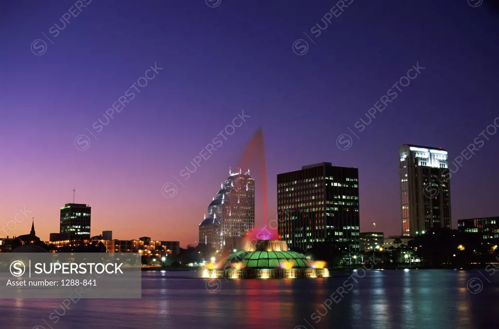 City on the waterfront lit up at dusk, Lake Eola, Orlando, Florida, USA