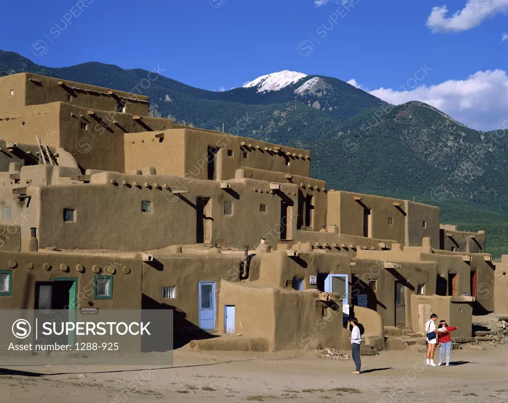 Tourists in front of mud huts, Taos Pueblo, New Mexico, USA