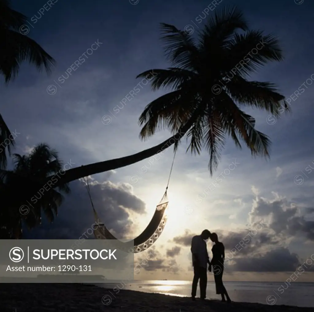 Silhouette of a young couple standing on the beach