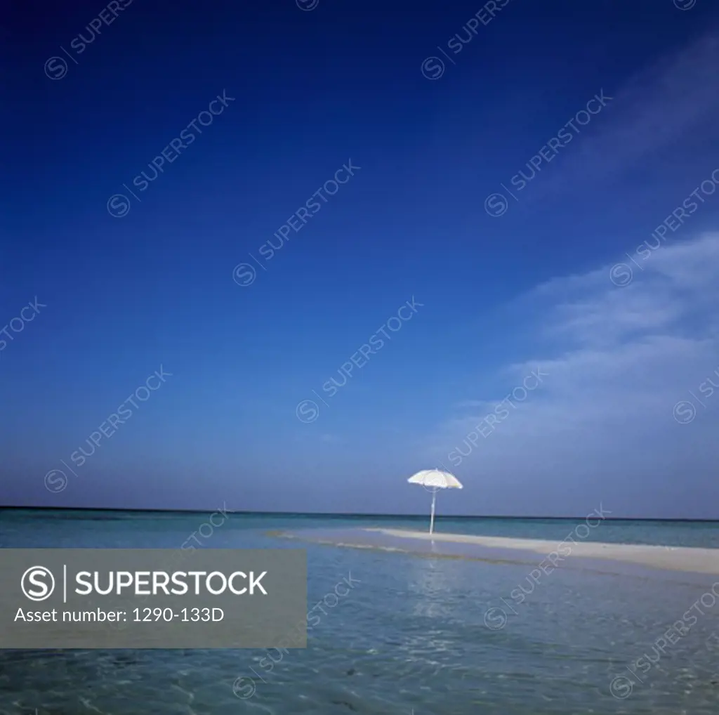 Beach umbrella surrounded by water
