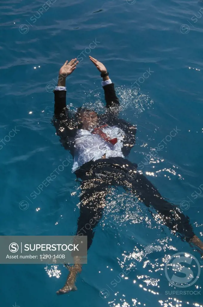 Businessman drowning in the ocean