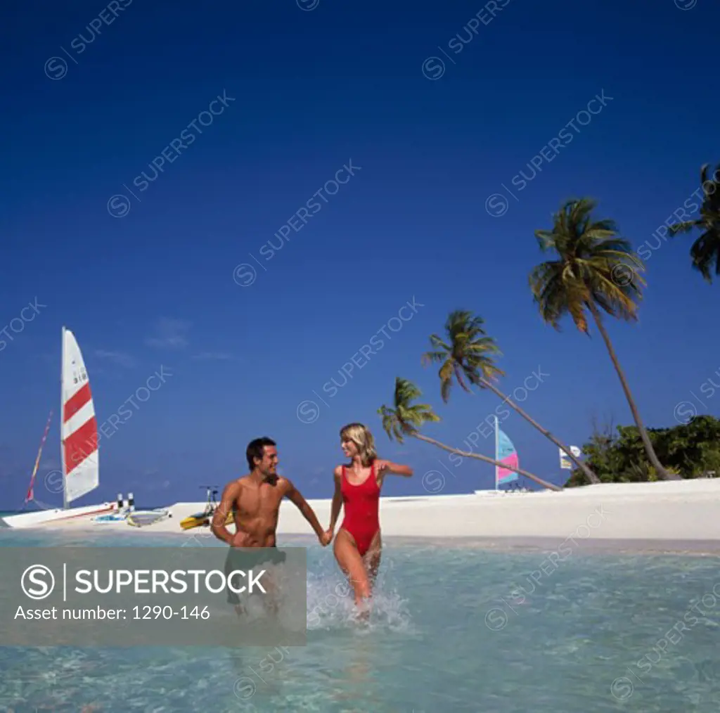 Young couple wading in water