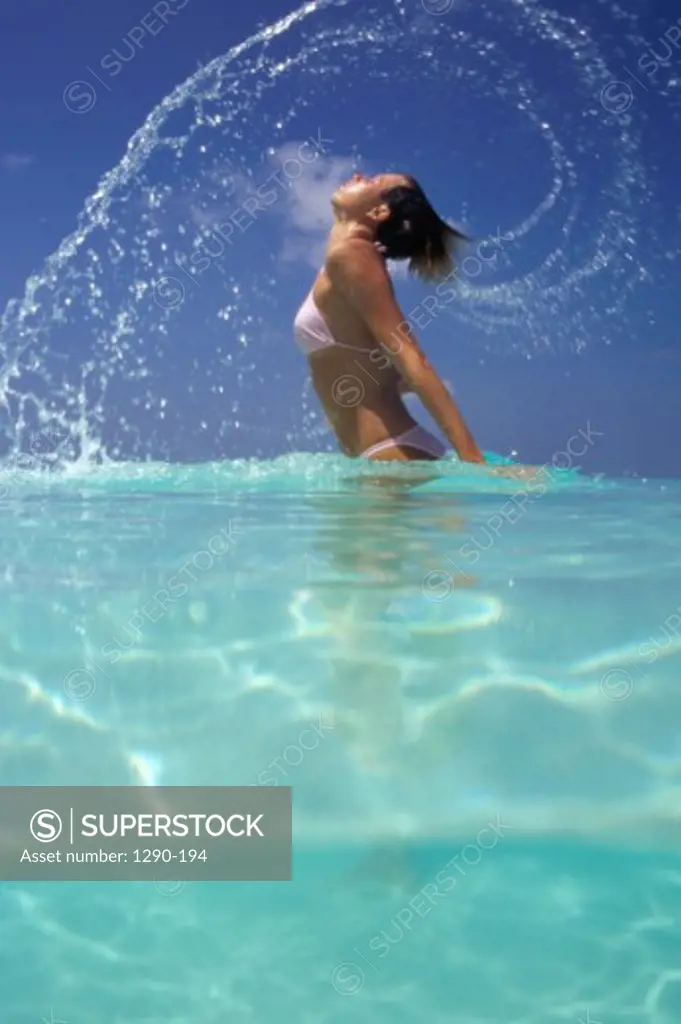 Side profile of a young woman splashing water, Maldives