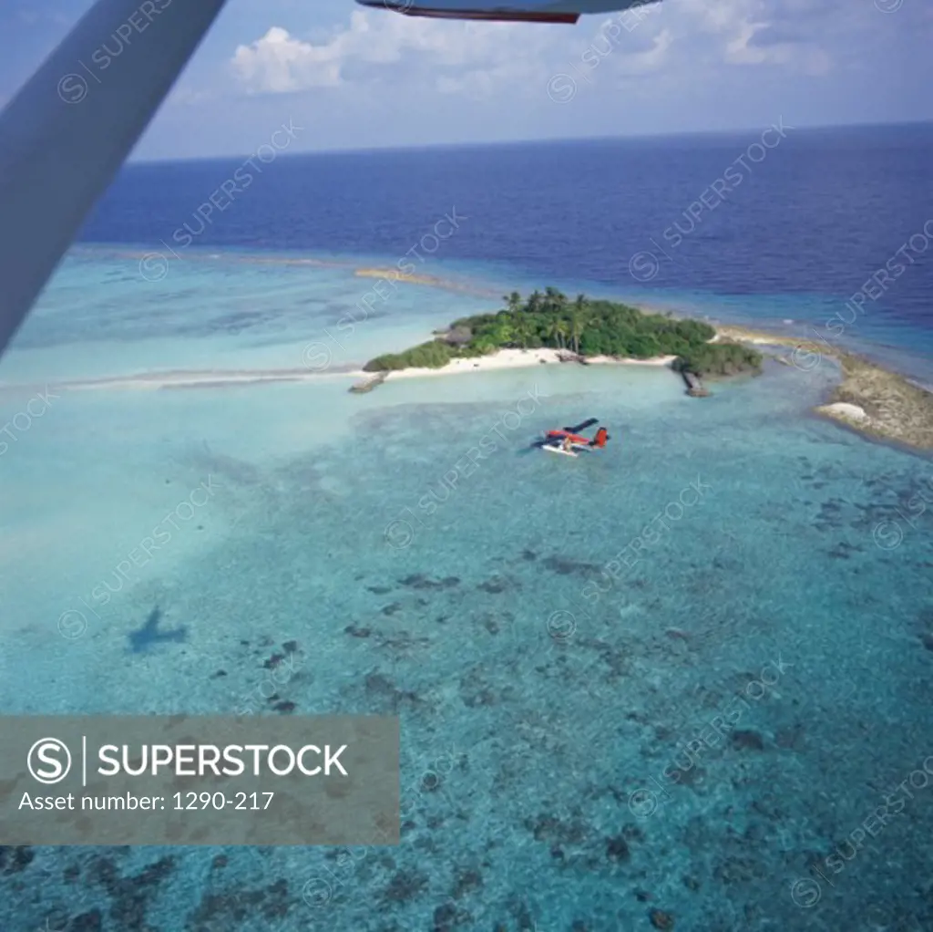 Aerial view of an island and a seaplane in the ocean, Maldives