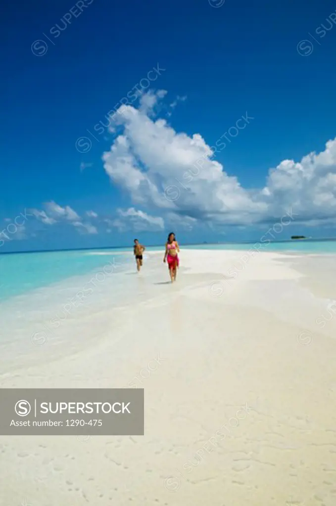 Young couple running on the beach, Maayafushi, Maldives