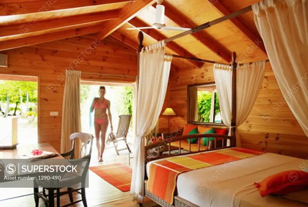 Young woman entering the bedroom, Meeru Island Resort, North Male Atoll, Maldives