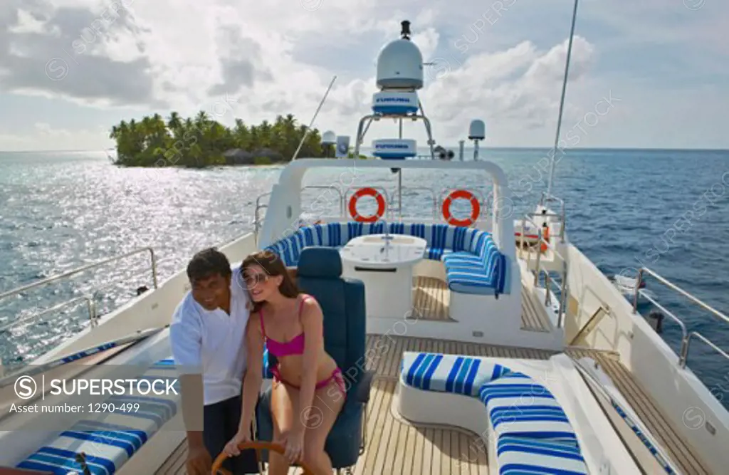 High angle view of a young couple driving a boat, Maayafushi, Maldives