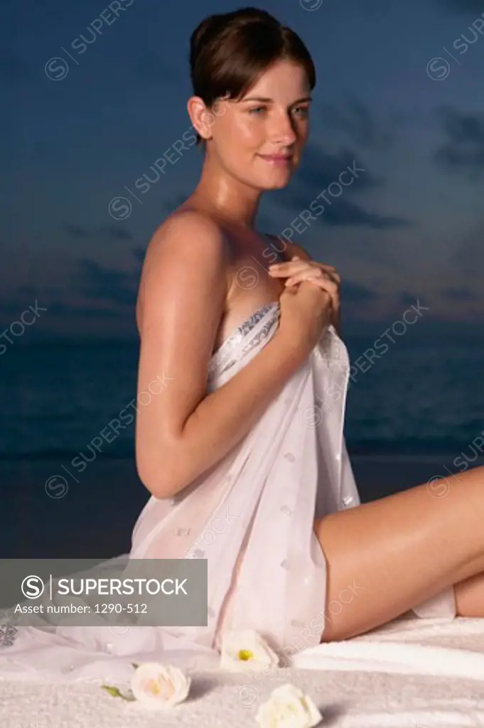 Side profile of a young woman sitting on the beach