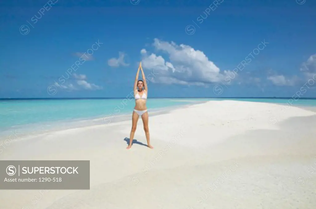 Young woman exercising on the beach, Maayafushi, Maldives