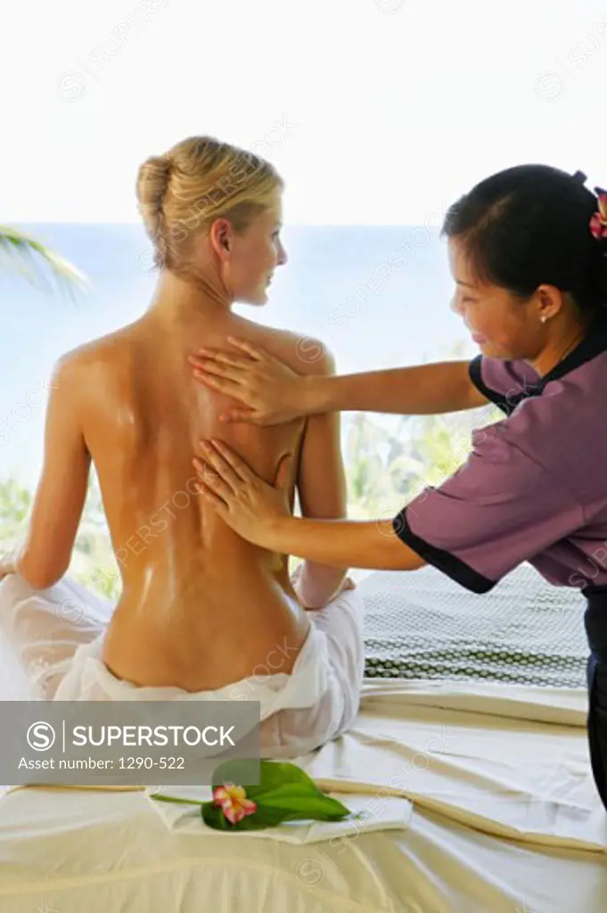 Rear view of a young woman getting a back massage from a massage therapist, Banyan Tree Hotel, Anse Intendance, Mahe Island, Seychelles