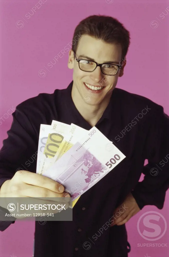 Portrait of a young man holding paper money