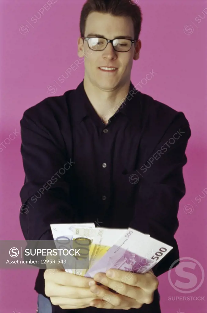 Portrait of a young man holding paper money