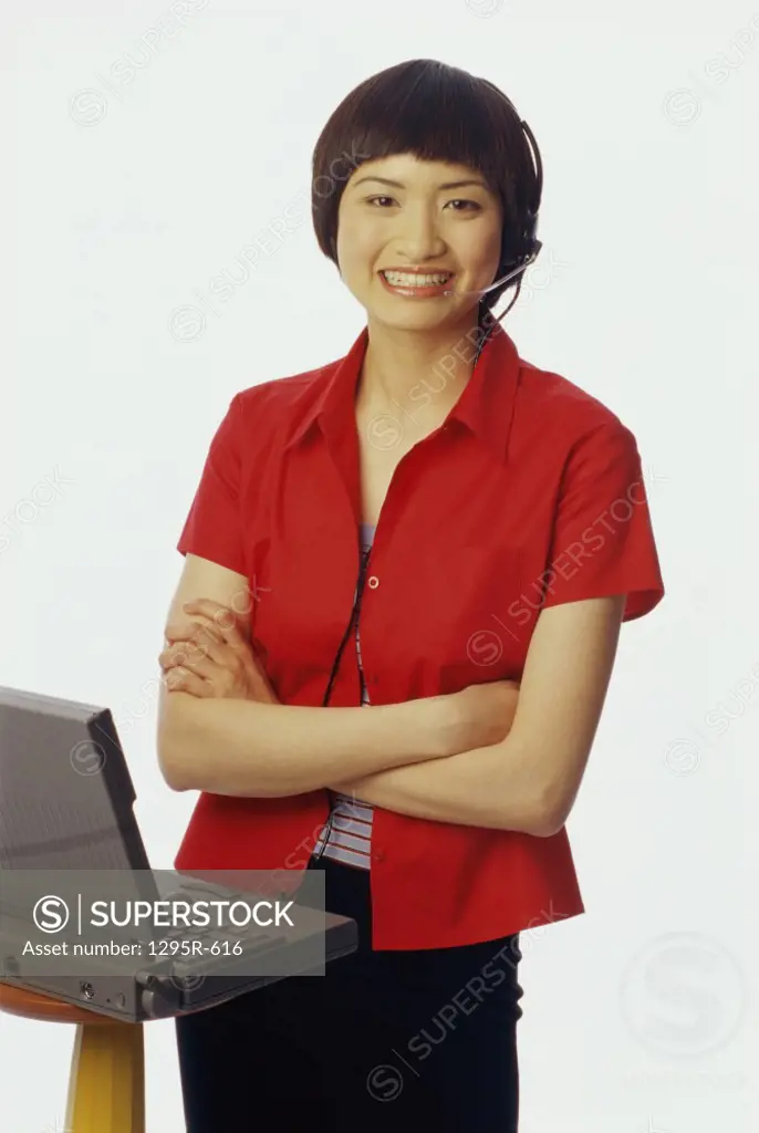 Portrait of a young woman standing in front of a laptop