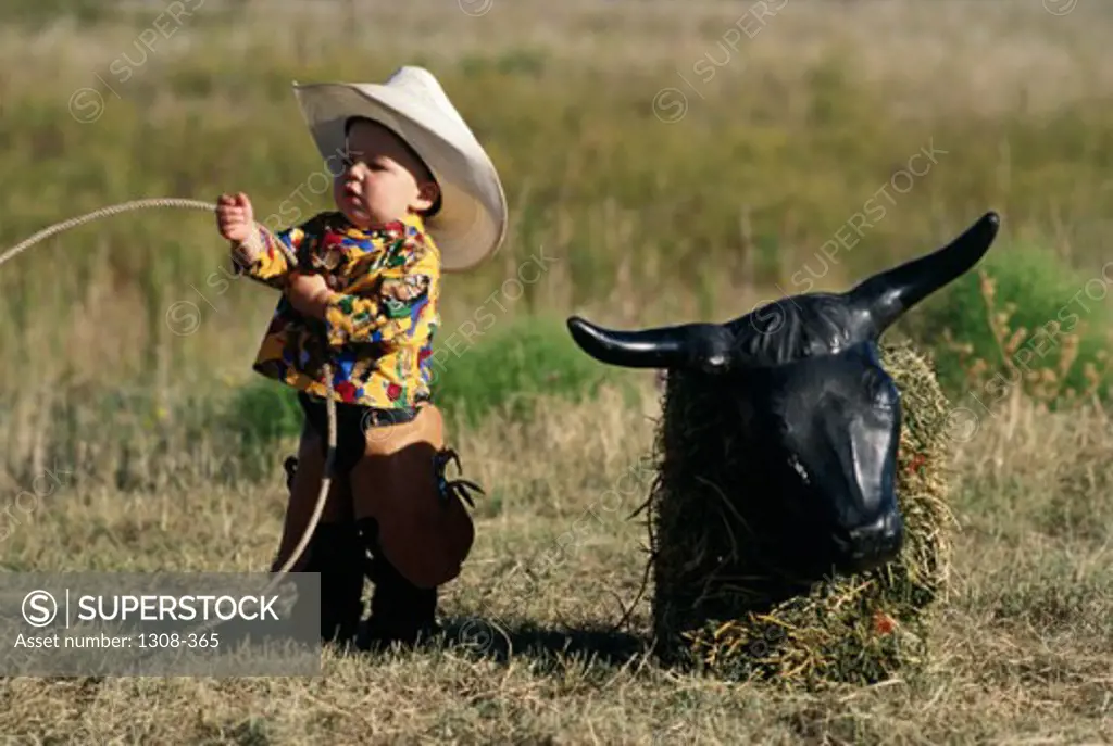 Boy dressed as a cowboy holding a lasso