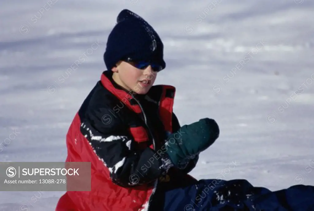 Boy sitting in snow