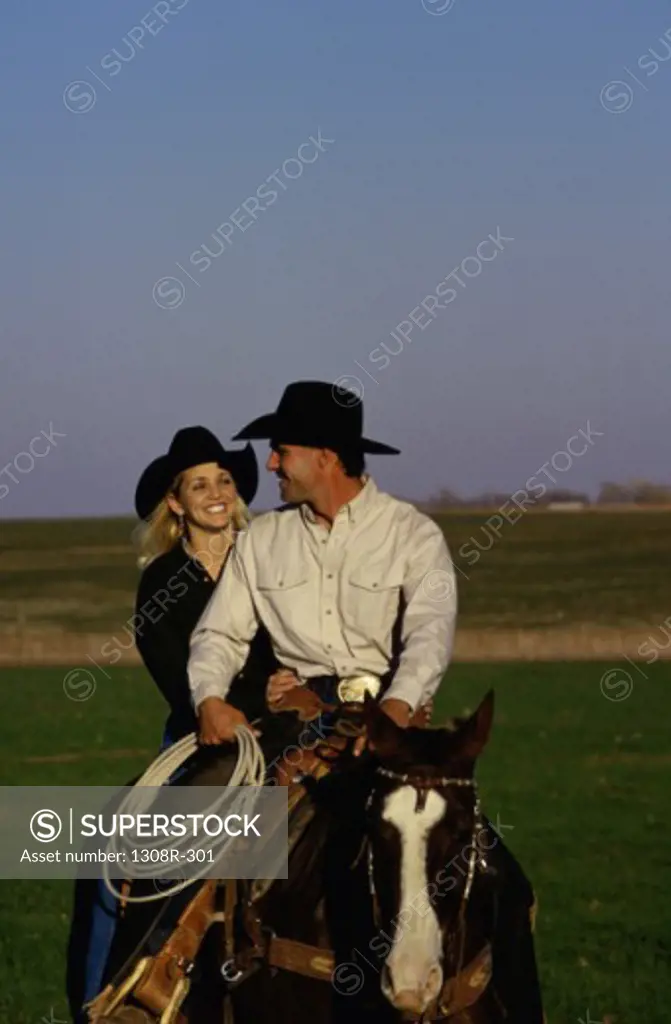 Young couple sitting on a horse