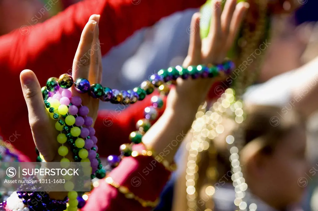 Close-up of human hands holding necklaces, Mardi Gras, New Orleans, Louisiana, USA