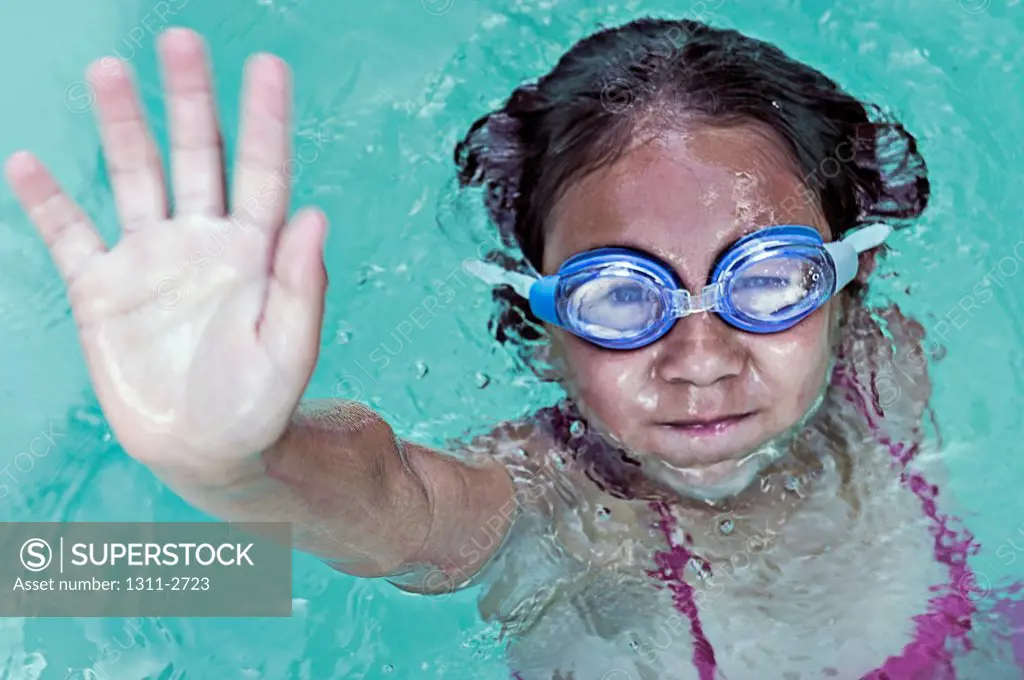 Young female swimmer waves, 'hello.'