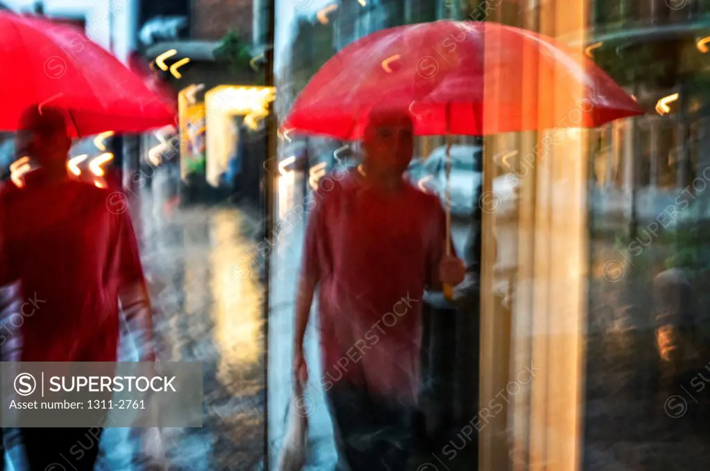 Reflections of a man walking through the rain in The French Quarter of New Orleans.