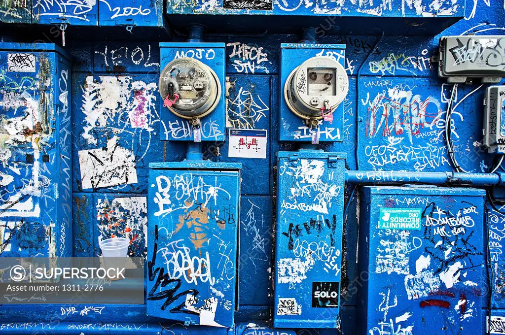 Blue paint, Elctric meters and grafitti turn a wall into a kind of Street art.