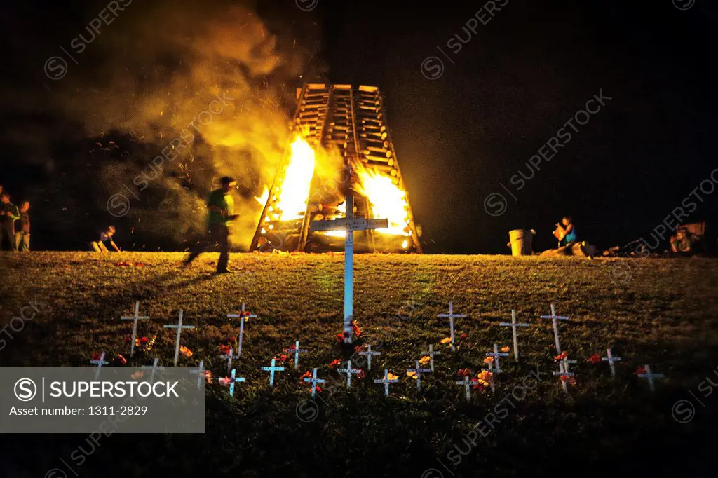 Bonfires along The Mississippi River, lighted on Christmas Eve to guide Santa CLaus to New Orleans. This is special the crosses are used to commorate the mass shooting at Newtown, Conn.