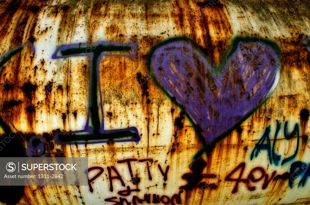 Rusted water tanks serves as a back drop for grafitti inspired love.