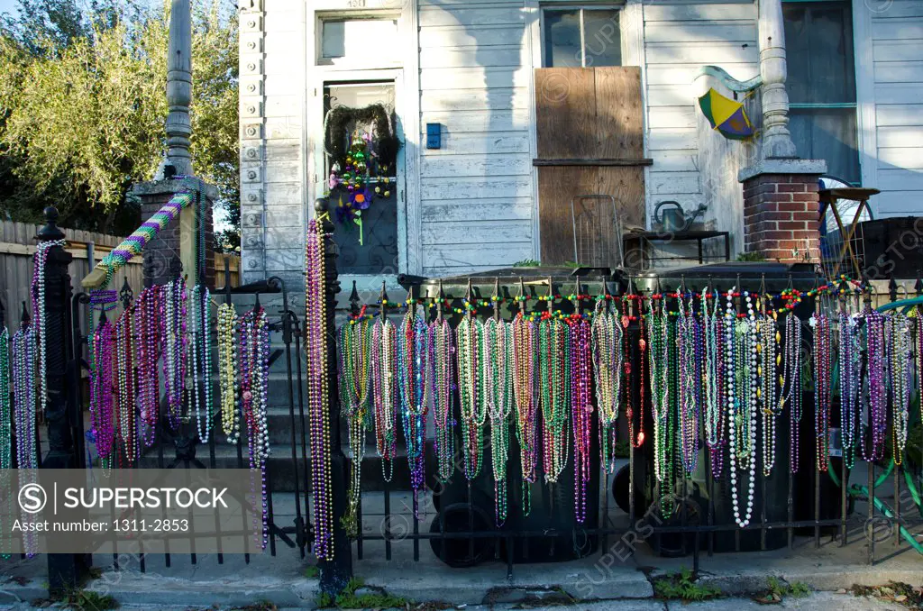 Mardi Gras beads adorn the fence of a hosue found on Magazine Street, Uptown, New Orleans.