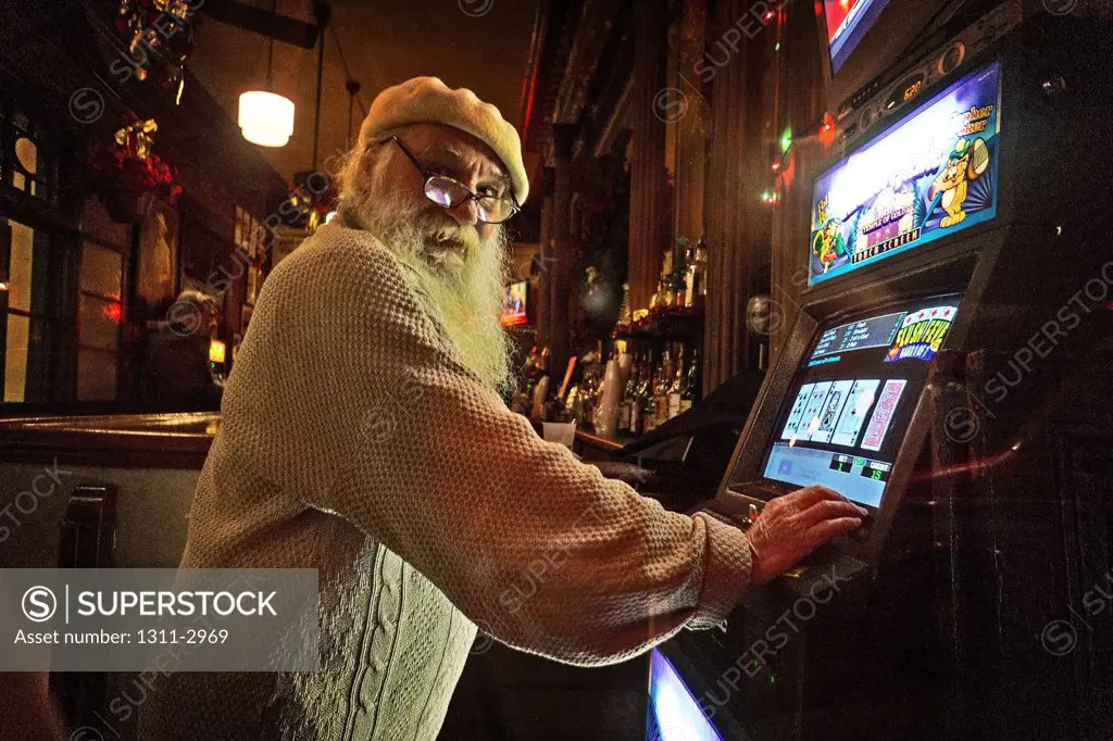 A real life santa Claus lookalike plays a slot machine in The French Quarter.