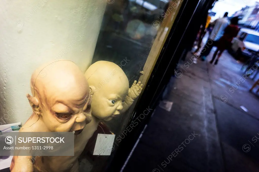 Really evil looking King Cake babies peer out of a store window at passersby.