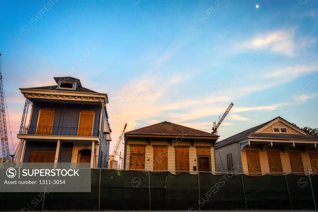 Construction site with boarded up houses that will soon be restored after the construction is complete.