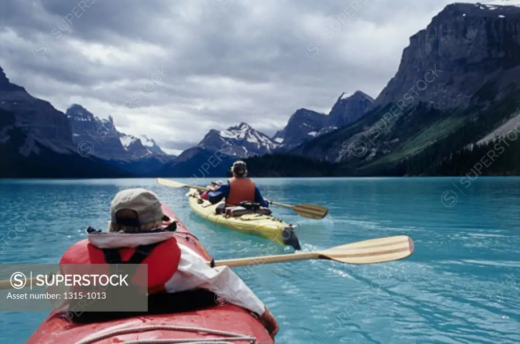 Rear view of two people kayaking in a lake, Maligne Lake, Banff National Park, Alberta, Canada