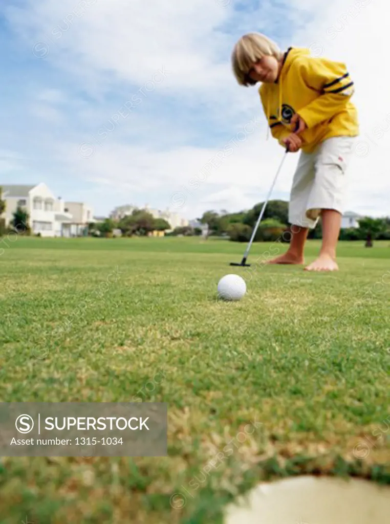 Low angle view of a boy playing golf, Cape Town, South Africa