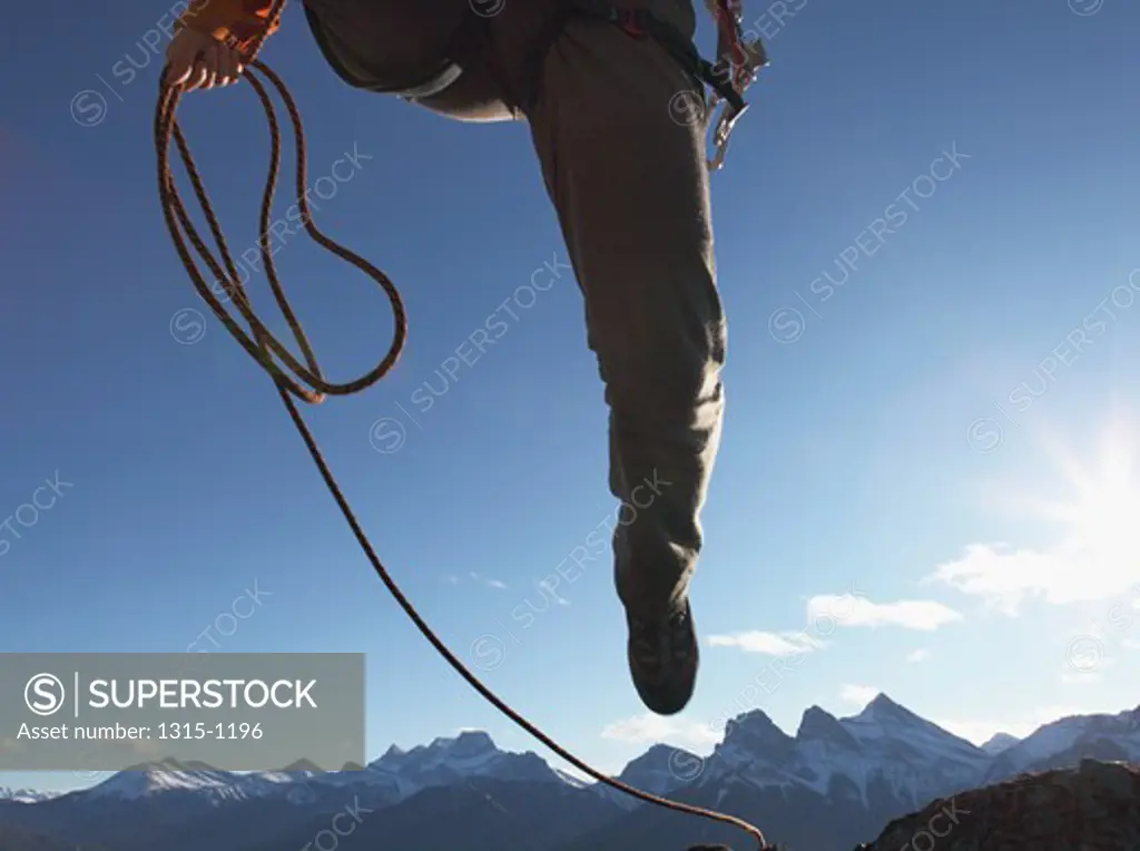 Low section view of a man leaping overhead from camera, Alberta, Canada