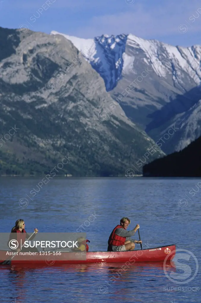 Side profile of parents canoeing in a lake with their daughter, Banff National Park, Alberta, Canada