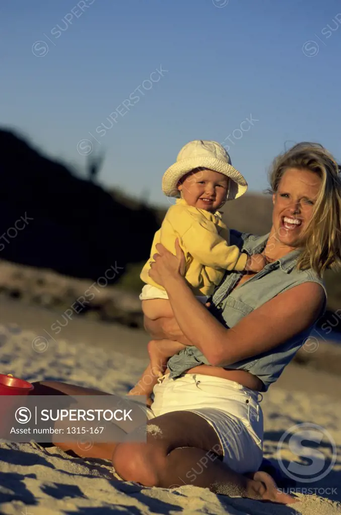 Portrait of a mother carrying her son on the beach, Baja California, Mexico