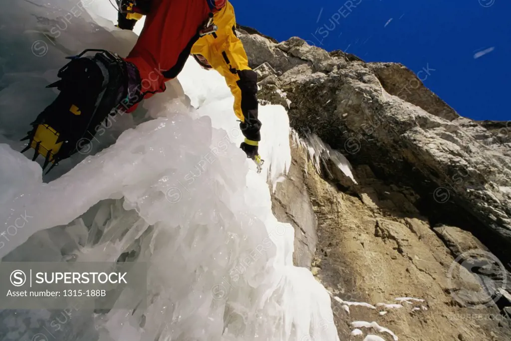 Low angle view of a man climbing a mountain, Alberta, Canada