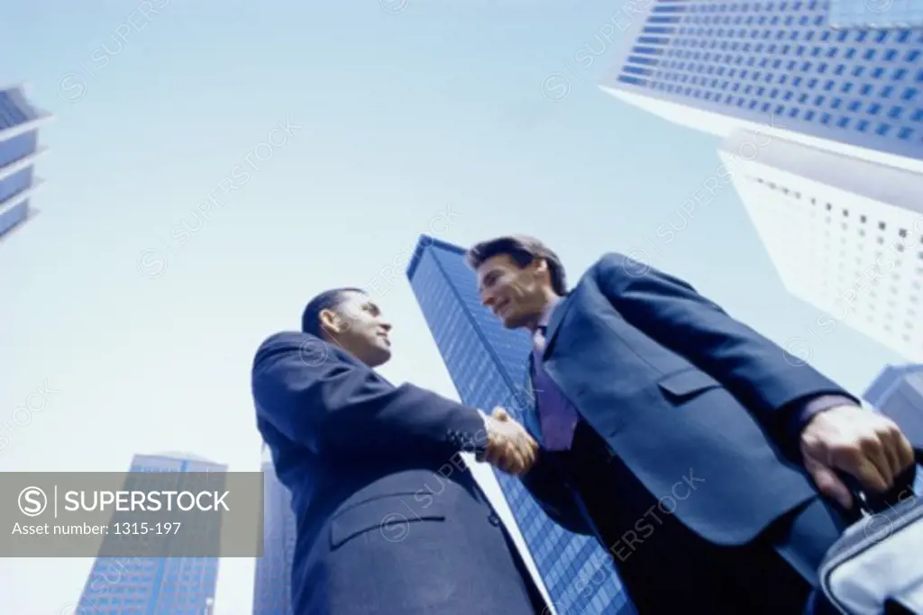Low angle view of two businessmen shaking hands