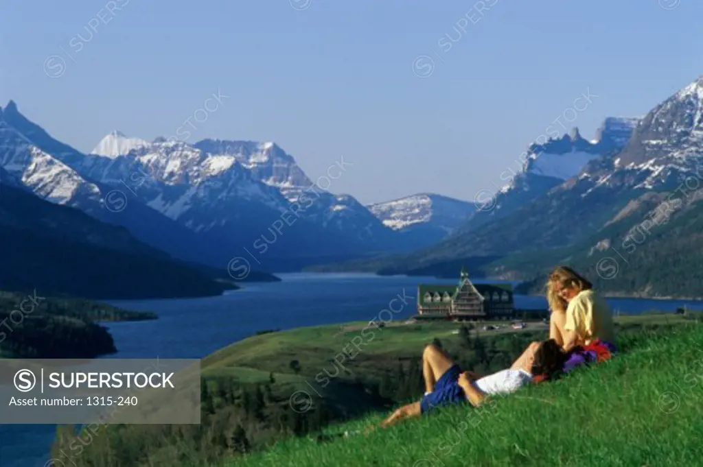 Young couple relaxing on the grass, Waterton Lakes National Park, Alberta, Canada