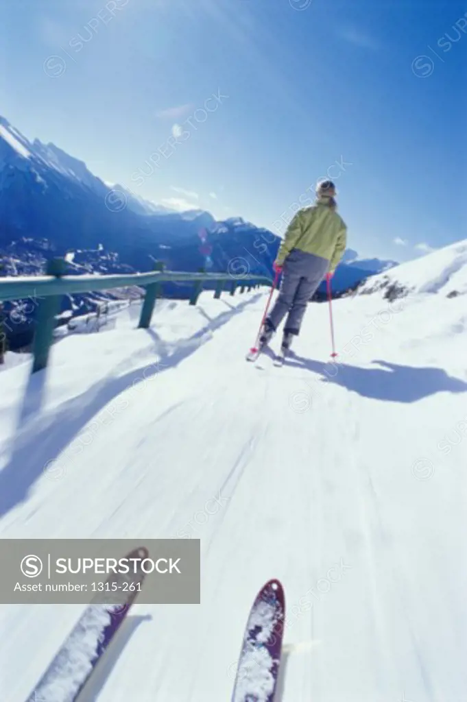 Rear view of a young woman skiing