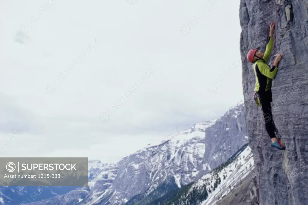 Side profile of a young woman climbing a rock face, Banff, Alberta, Canada
