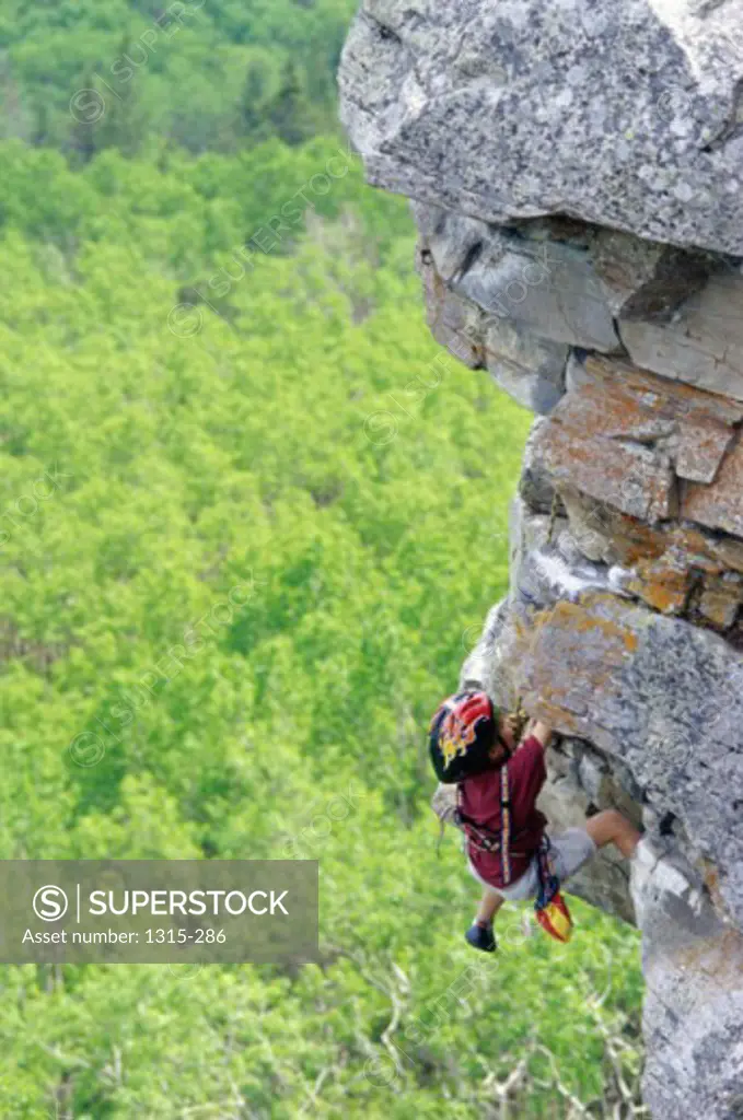 Child climbing up a cliff, Alberta, Canada